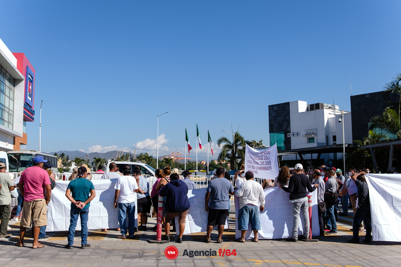 Manifestantes esperan la salida del presidente Obrador.