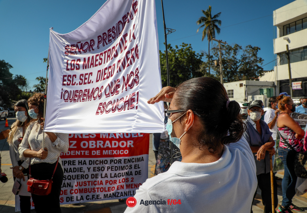Manifestantes con mantas y peticiones a problemas donde ya anteriormente le han hecho llegar escritos al Presidente. La contaminación del vaso 1 de la laguna de Cuyutlán por la CFE y el intento de instalar una mina de hierro en la comunidad de Canoas en Manzanillo.