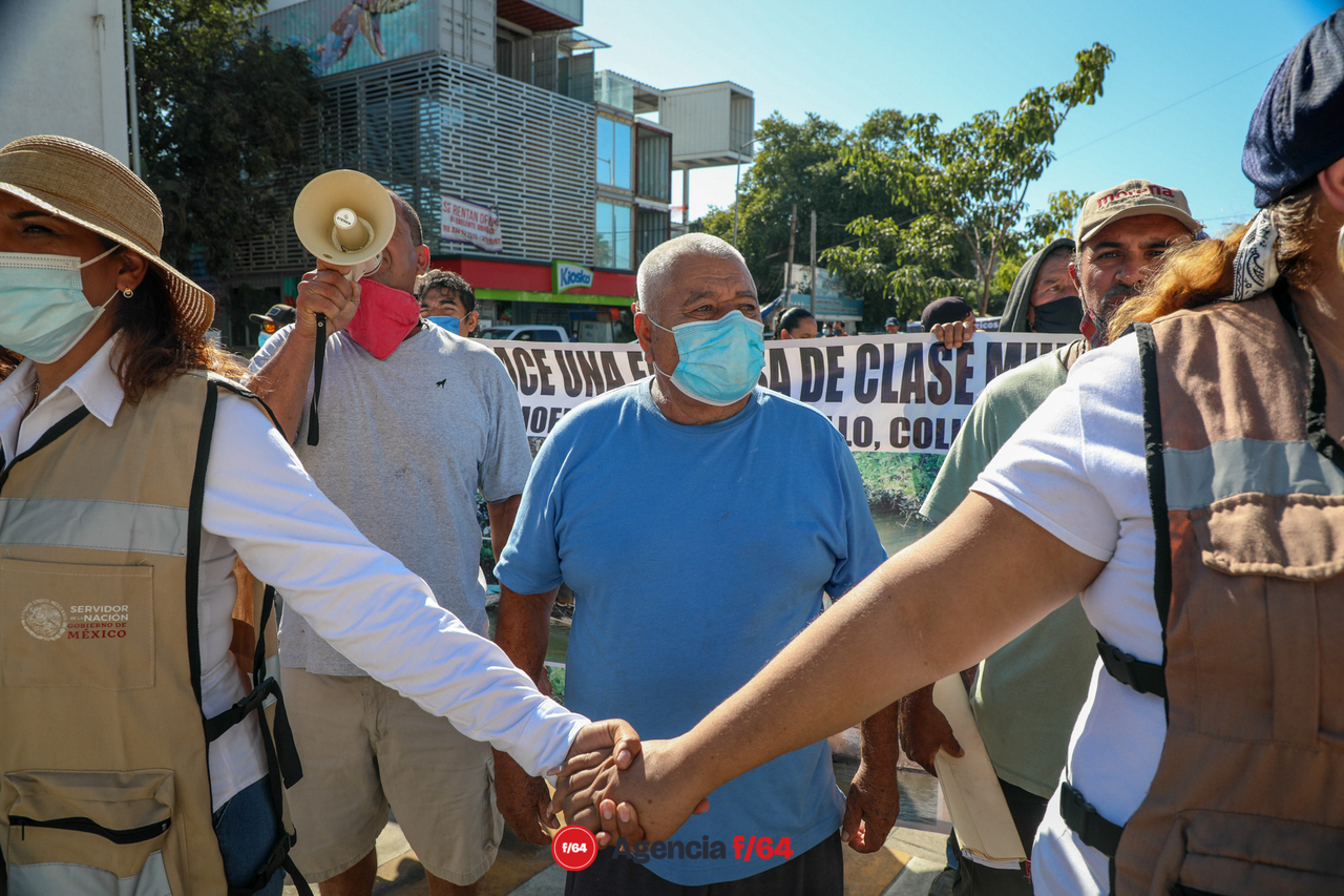 Manifestantes con mantas y peticiones a problemas donde ya anteriormente le han hecho llegar escritos al Presidente. La contaminación del vaso 1 de la laguna de Cuyutlán por la CFE y el intento de instalar una mina de hierro en la comunidad de Canoas en Manzanillo.