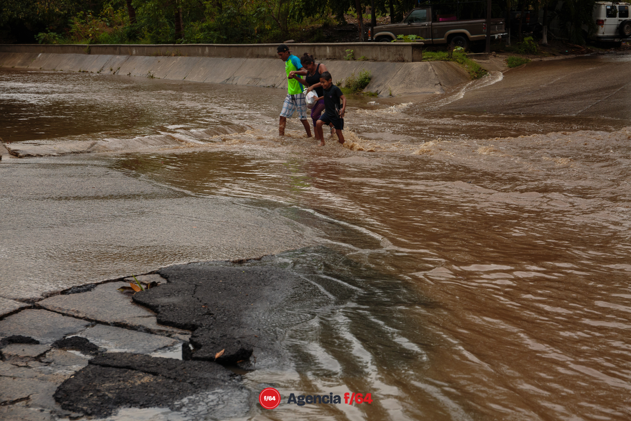 Familia cruza el arroyo De Santiago a pie en Manzanillo.