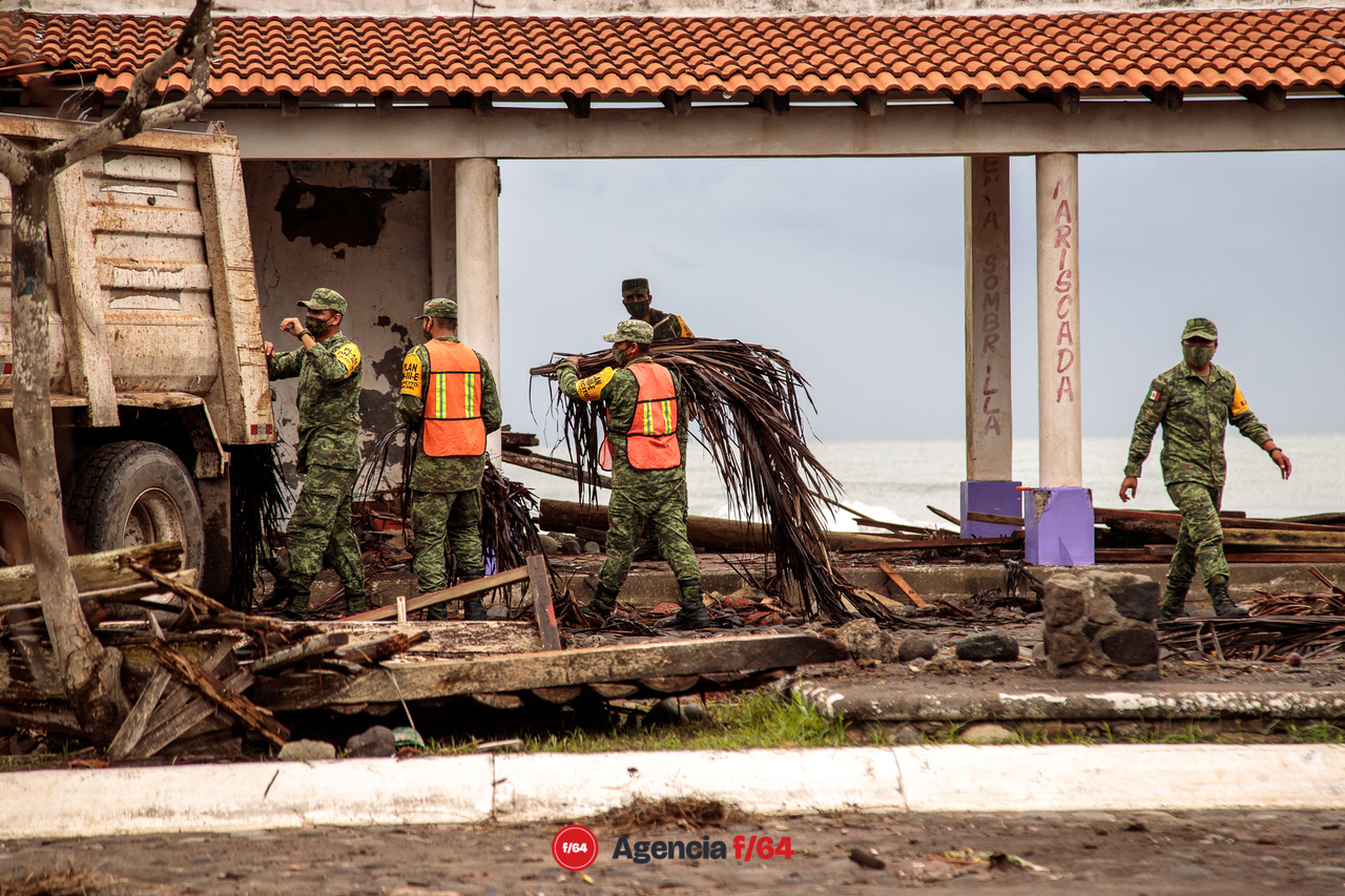 Pobladores y elementos del ejército realizan trabajos de limpieza después de las afectaciones que dejó el huracán Enrique en la comunidad.