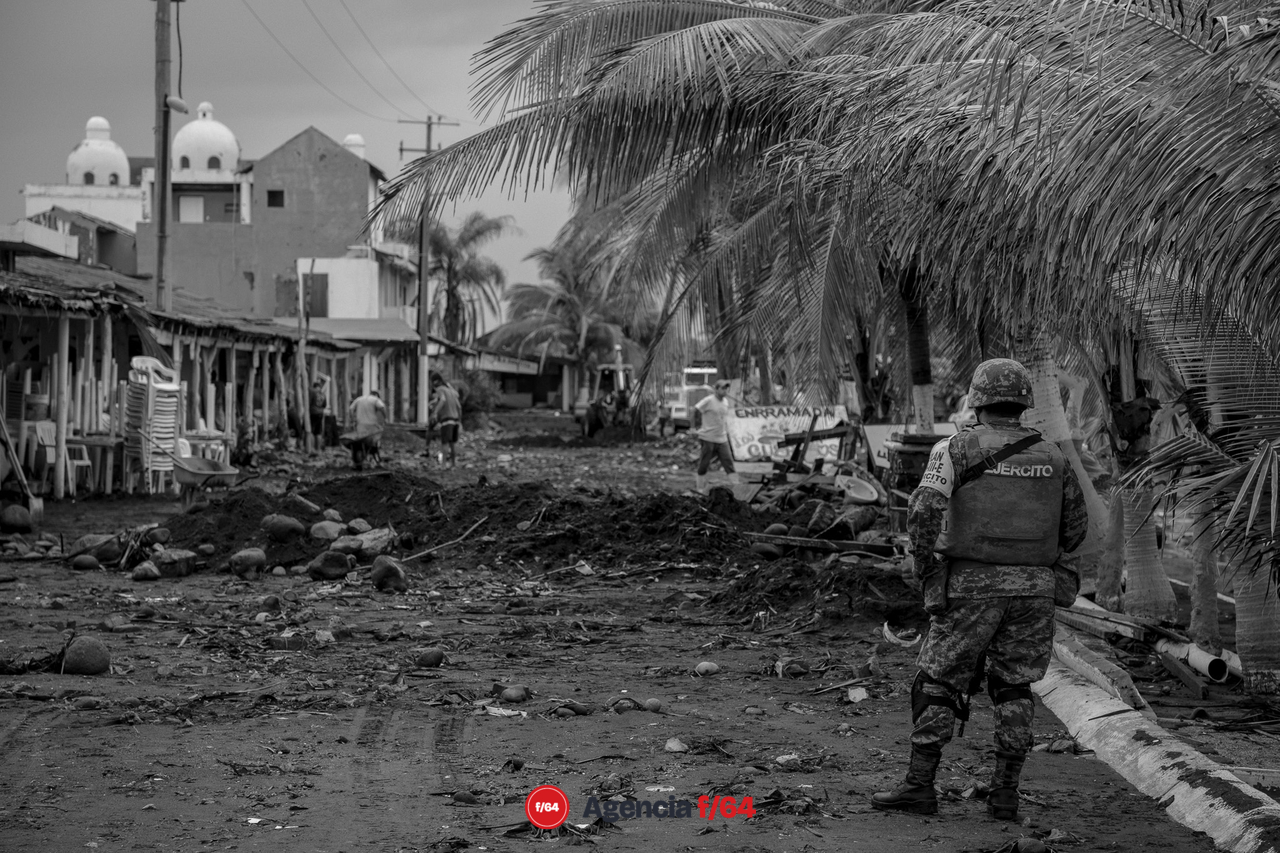 Pobladores y elementos del ejército realizan trabajos de limpieza después de las afectaciones que dejó el huracán Enrique en la comunidad.