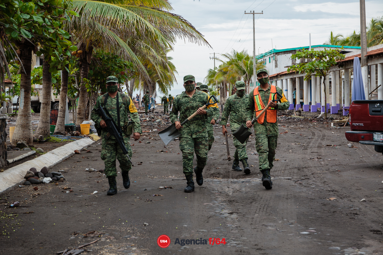 Pobladores y elementos del ejército realizan trabajos de limpieza después de las afectaciones que dejó el huracán Enrique en la comunidad.