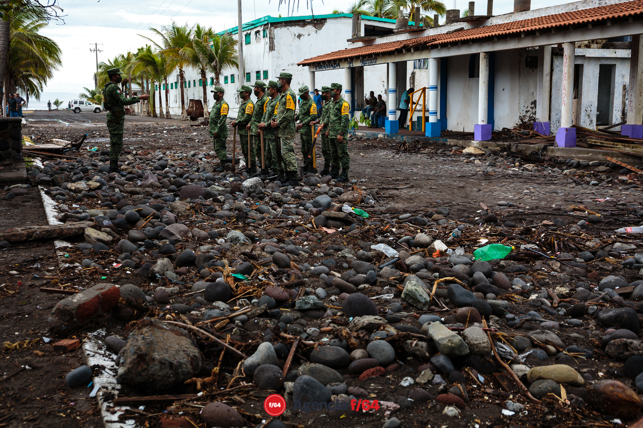 Pobladores y elementos del ejército realizan trabajos de limpieza después de las afectaciones que dejó el huracán Enrique en la comunidad.