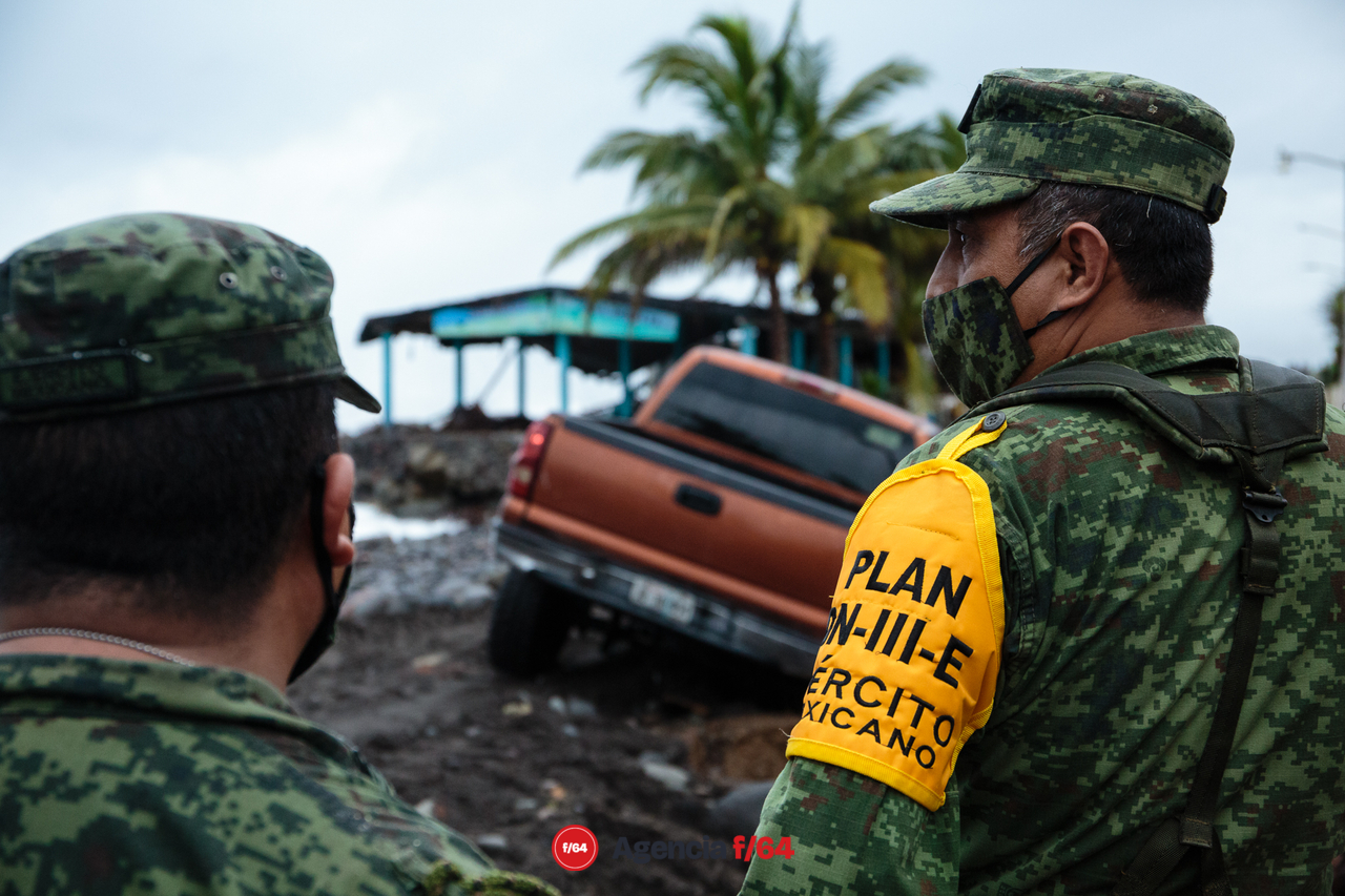 Pobladores y elementos del ejército realizan trabajos de limpieza después de las afectaciones que dejó el huracán Enrique en la comunidad.