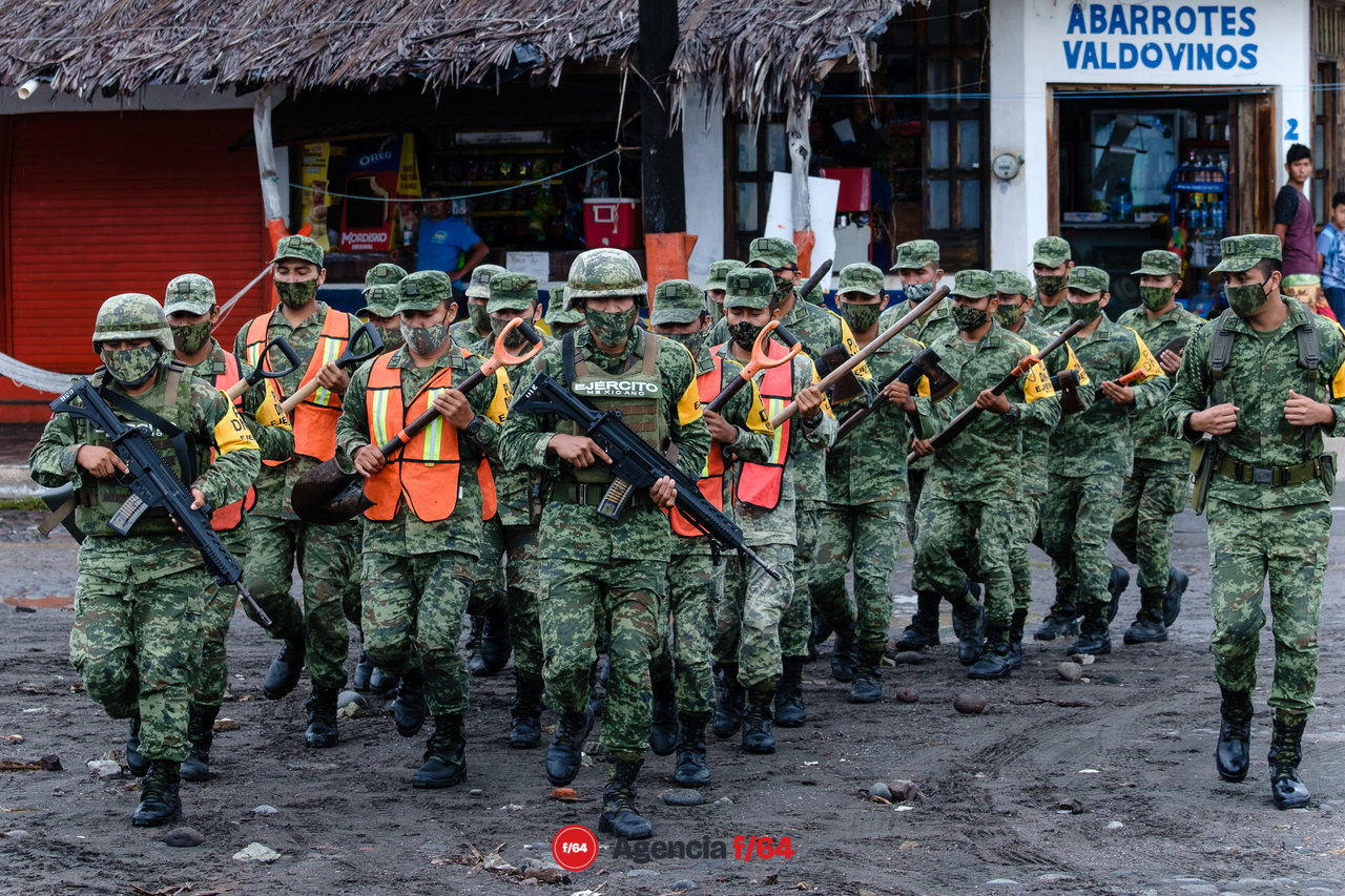 Pobladores y elementos del ejército realizan trabajos de limpieza después de las afectaciones que dejó el huracán Enrique en la comunidad.