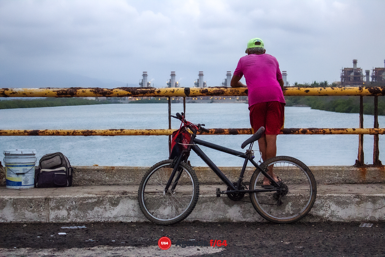 Un hombre pesca en el puente de Ventanas y al fondo vemos la Termoeléctrica. 

#LaDiaria 