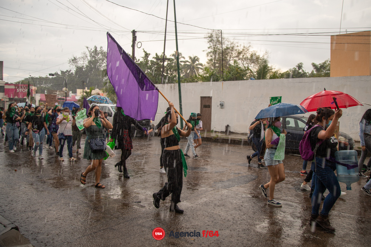 Contingente feminista marcha en dirección al Jardín Libertad bajo la intensa lluvia.