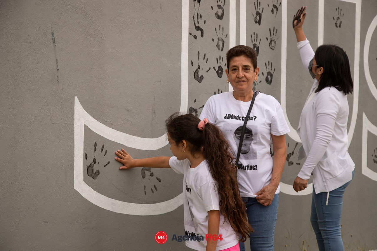 Pinta de nombres de desaparecidos y pinta de huellas de familiares.