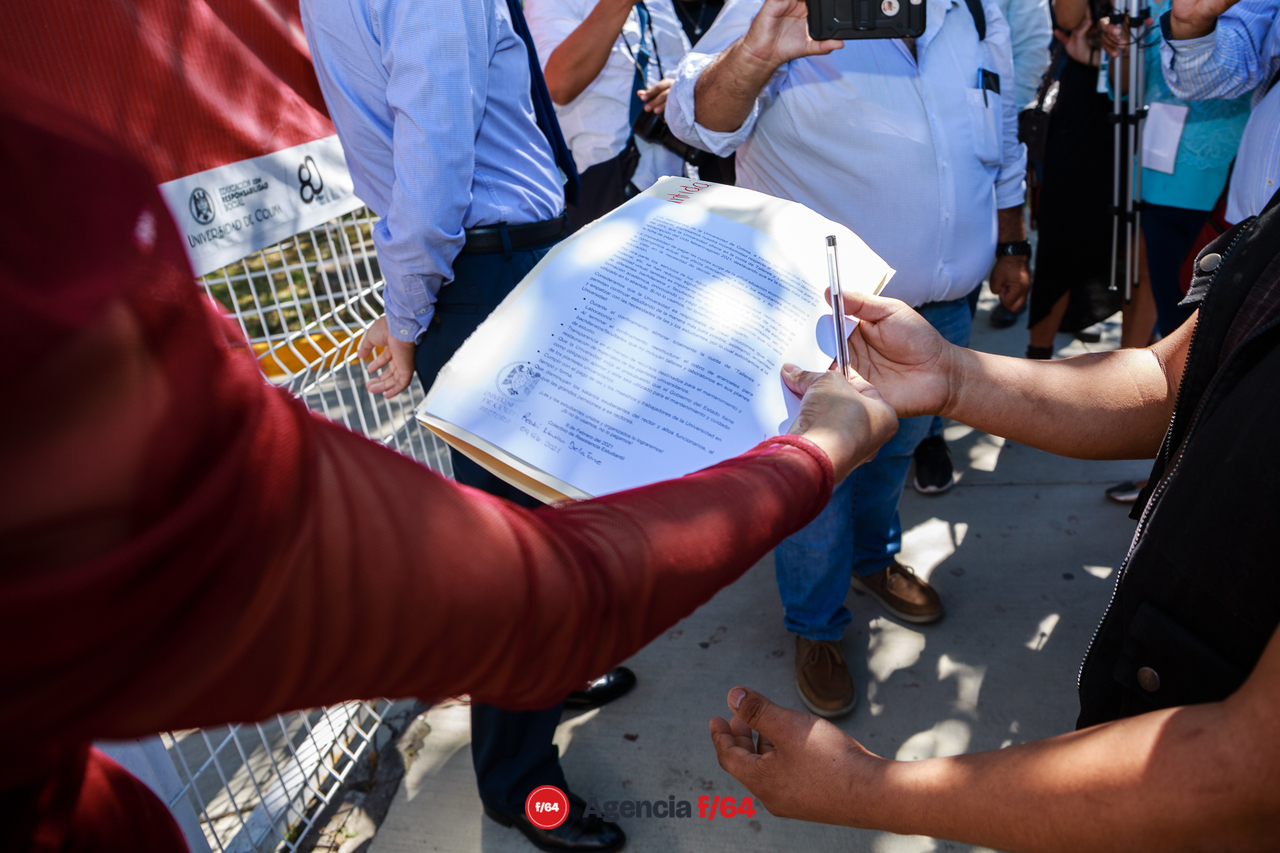 Recepción de los documentos de los estudiantes sobre la banqueta en la calle.