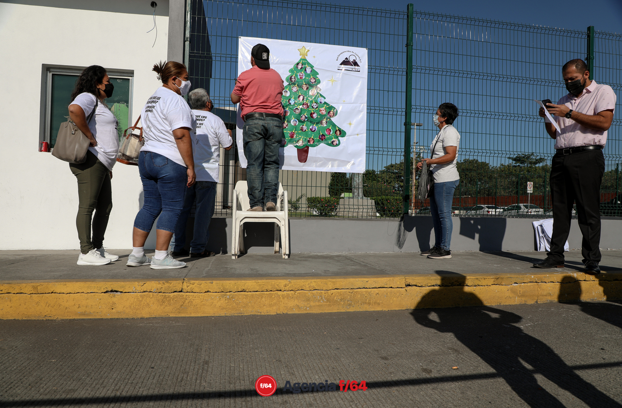Integrantes de la Red Desaparecidos en Colima en la instalación simbólica del Árbol Navideño “decorado” con múltiples esferas las cuales muestran y honran la memoria de sus Familiares Desaparecidos. Ubicación: Edificio de la Fiscalia General del Estado de Colima. 