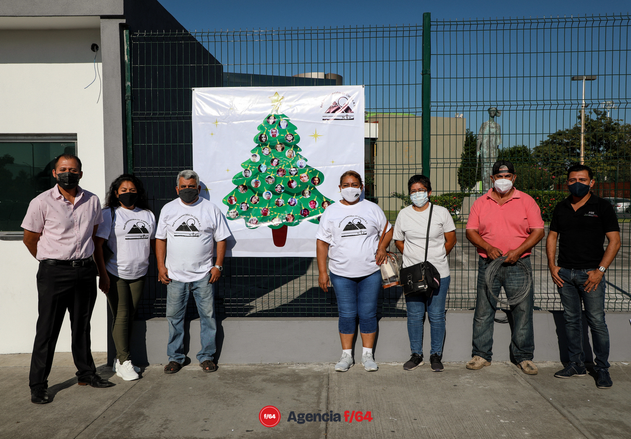 Integrantes de la Red Desaparecidos en Colima en la instalación simbólica del Árbol Navideño “decorado” con múltiples esferas las cuales muestran y honran la memoria de sus Familiares Desaparecidos. Ubicación: Edificio de la Fiscalia General del Estado de Colima. 