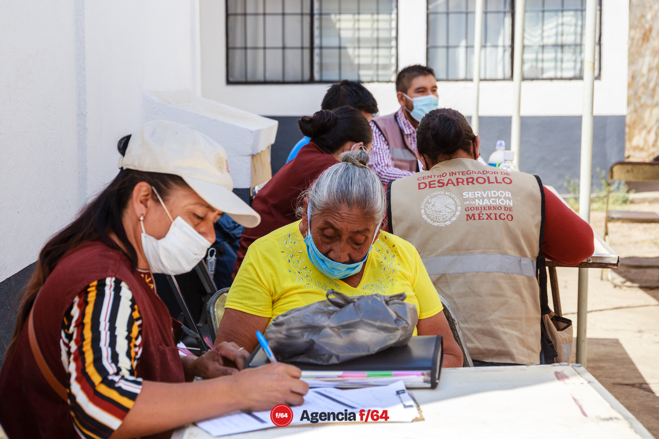 Personal de Gobierno ayudan a los adultos mayores a llenar el formato de registro.