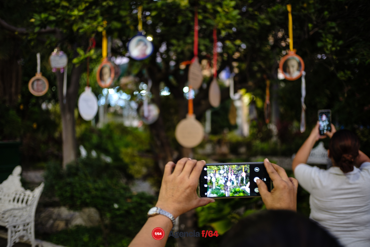 Familiares toman fotografías una vez finalizada la instalación en el jardín Libertad de la ciudad de Colima.