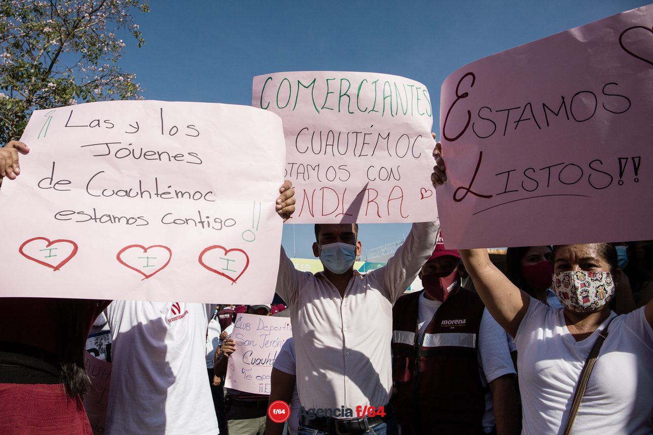 Simpatizantes con cartulinas mostrando su apoyo.