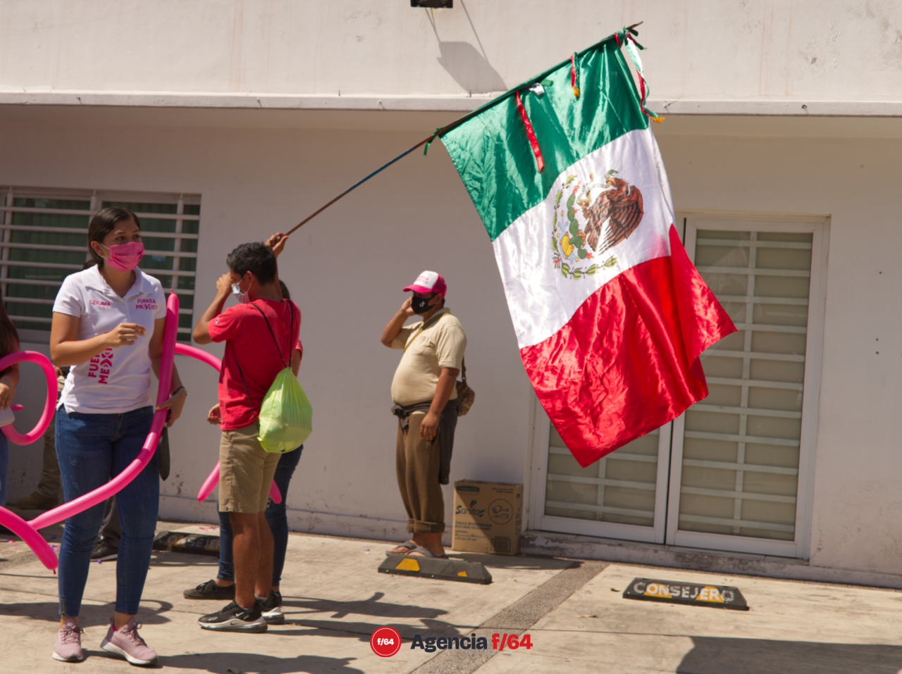 Simpatizante de con bandera de México,  durante el registro de Claudia Yánez.