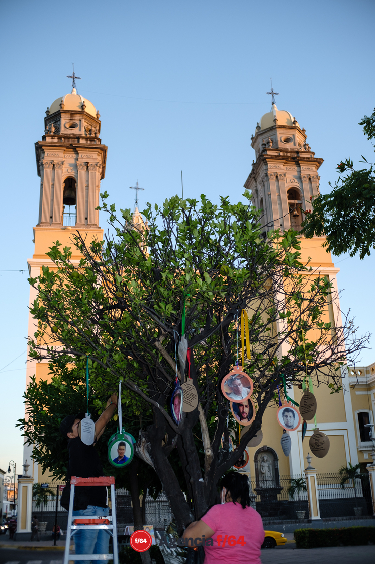 Familiares instalando esferas con información de desaparecidos en el jardín Libertad de la ciudad de Colima.