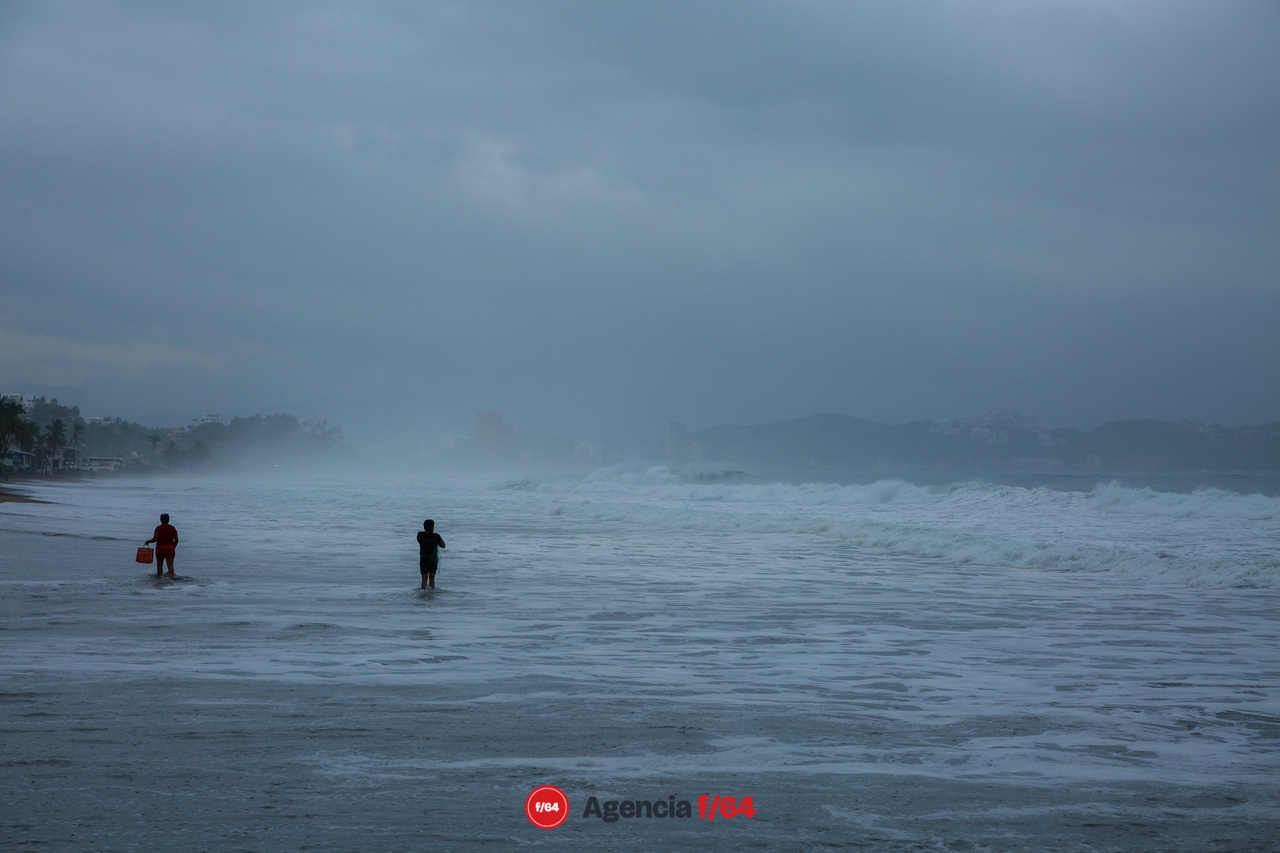 Pescadores bajo tormenta en la playa Miramar en Manzanillo.